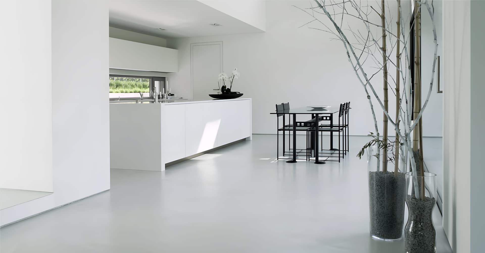 Un grand salon avec un sol en béton ciré gris.